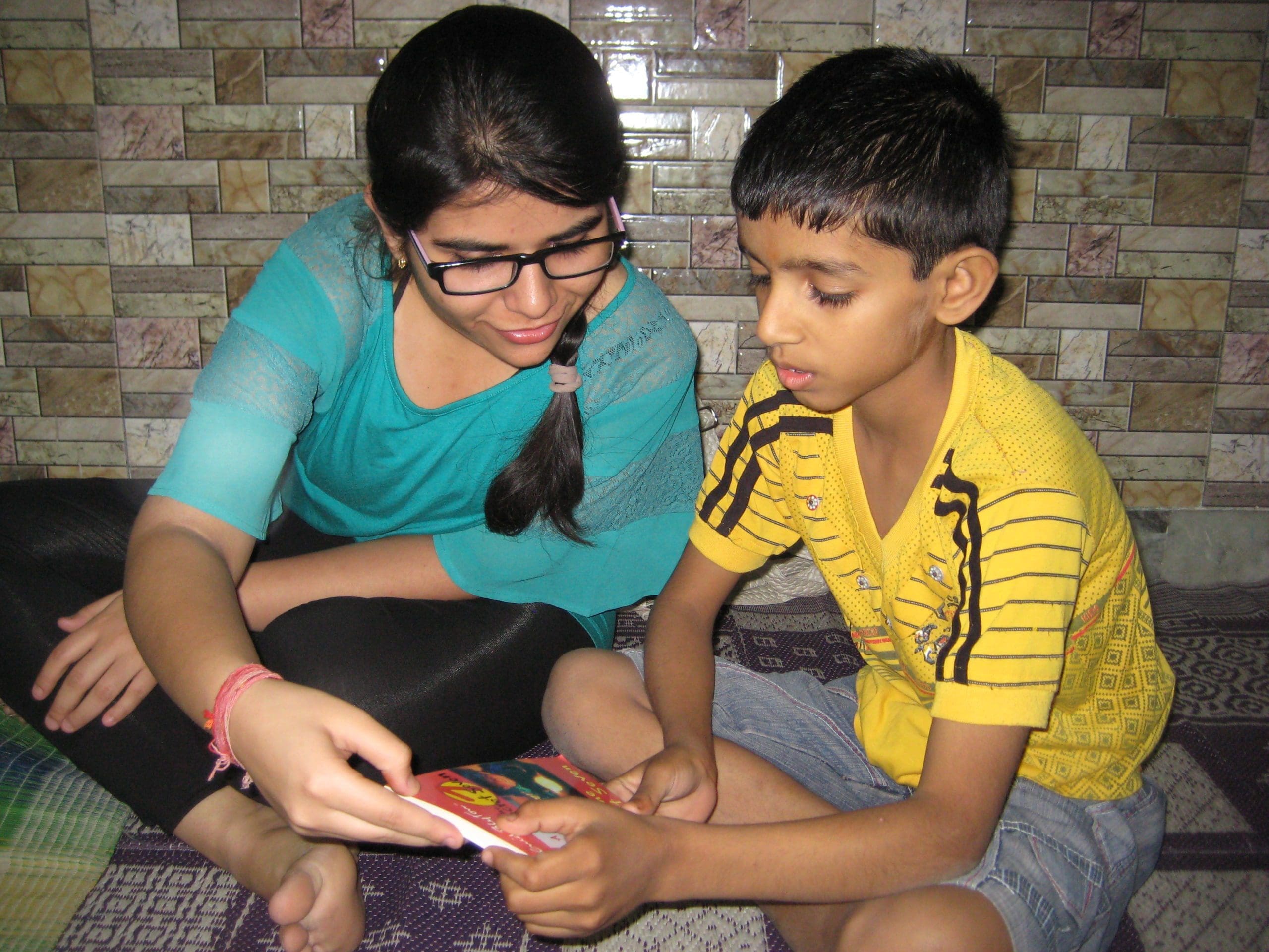 A volunteer helping a kid with reading