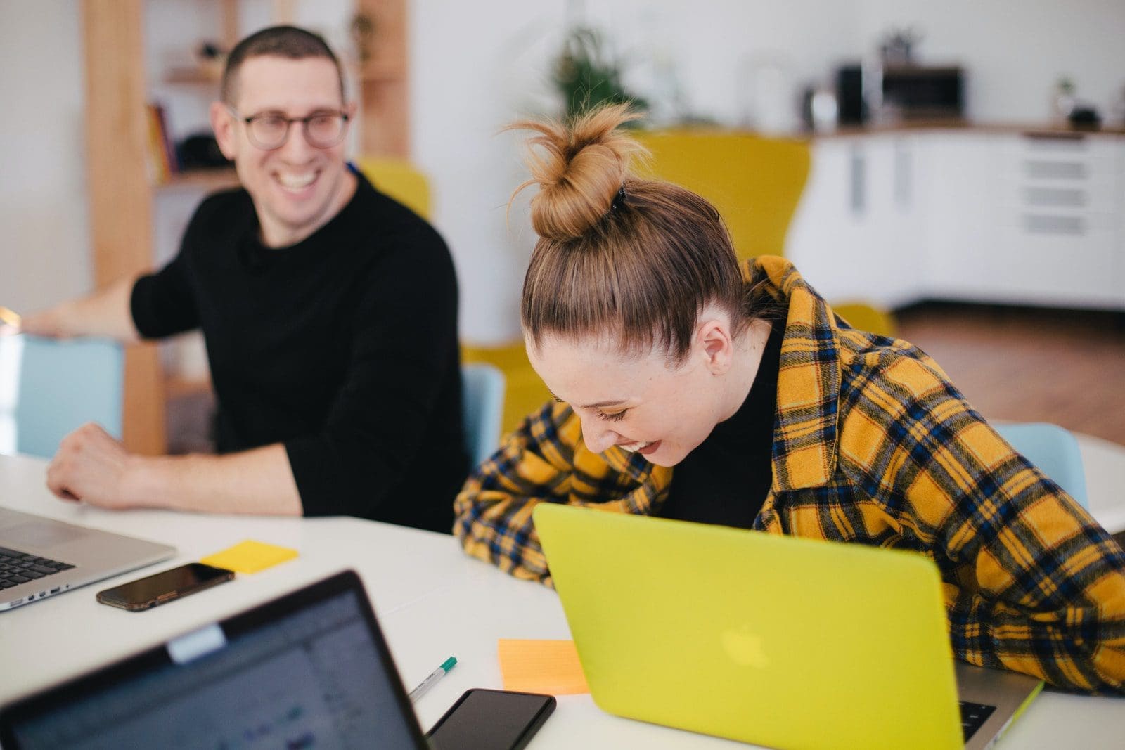 study in australia man and woman laughing while sitting in front of laptops