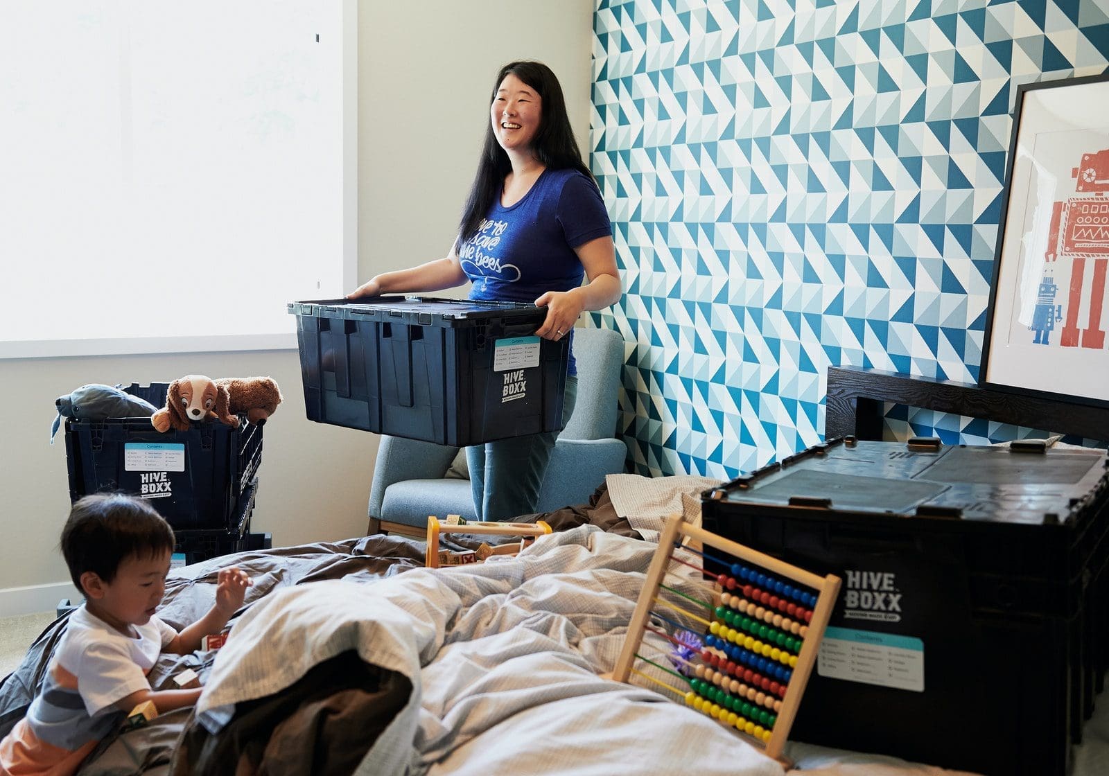 moving company unpacking woman in blue sleeveless dress sitting on bed