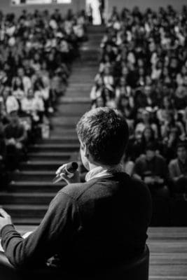 man speaking in front of crowd public speaking