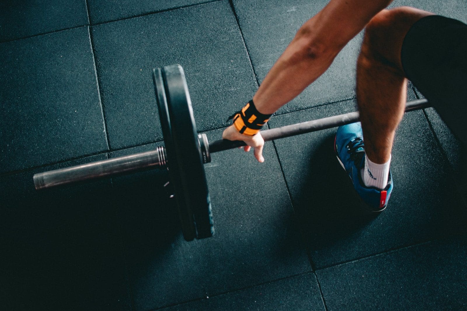 man holding black barbell gym membership