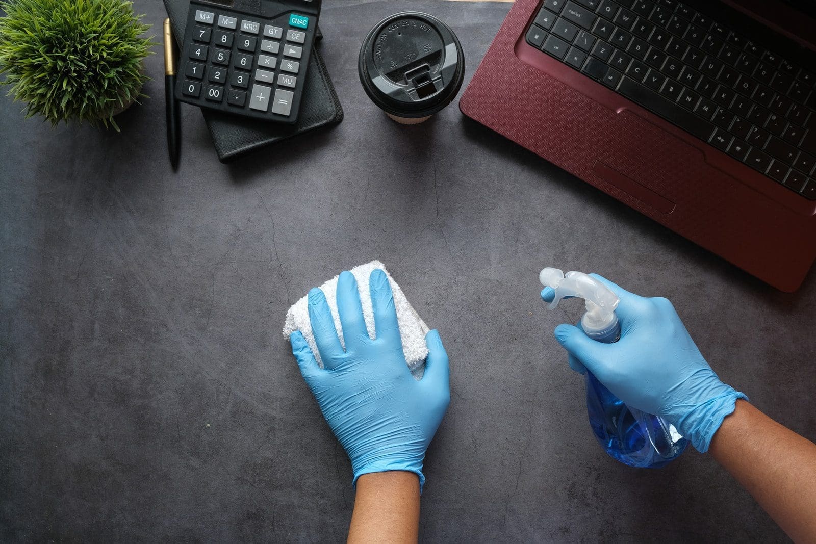 expert cleaning person in blue long sleeve shirt sitting beside black laptop computer