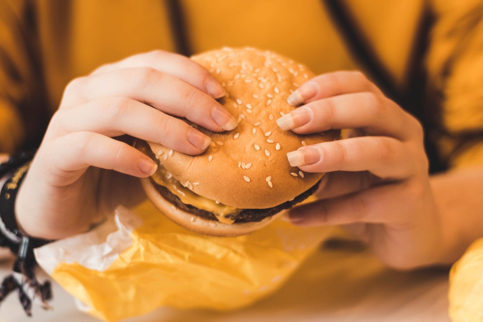 person holding hamburger McDonald's
