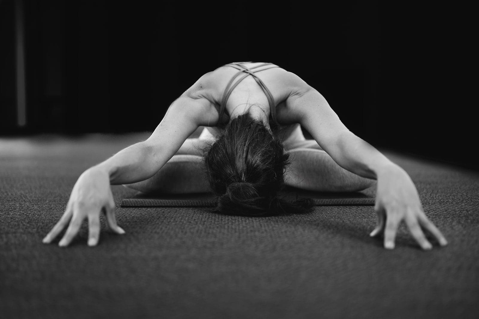fat burning woman in white tank top bending her body on floor