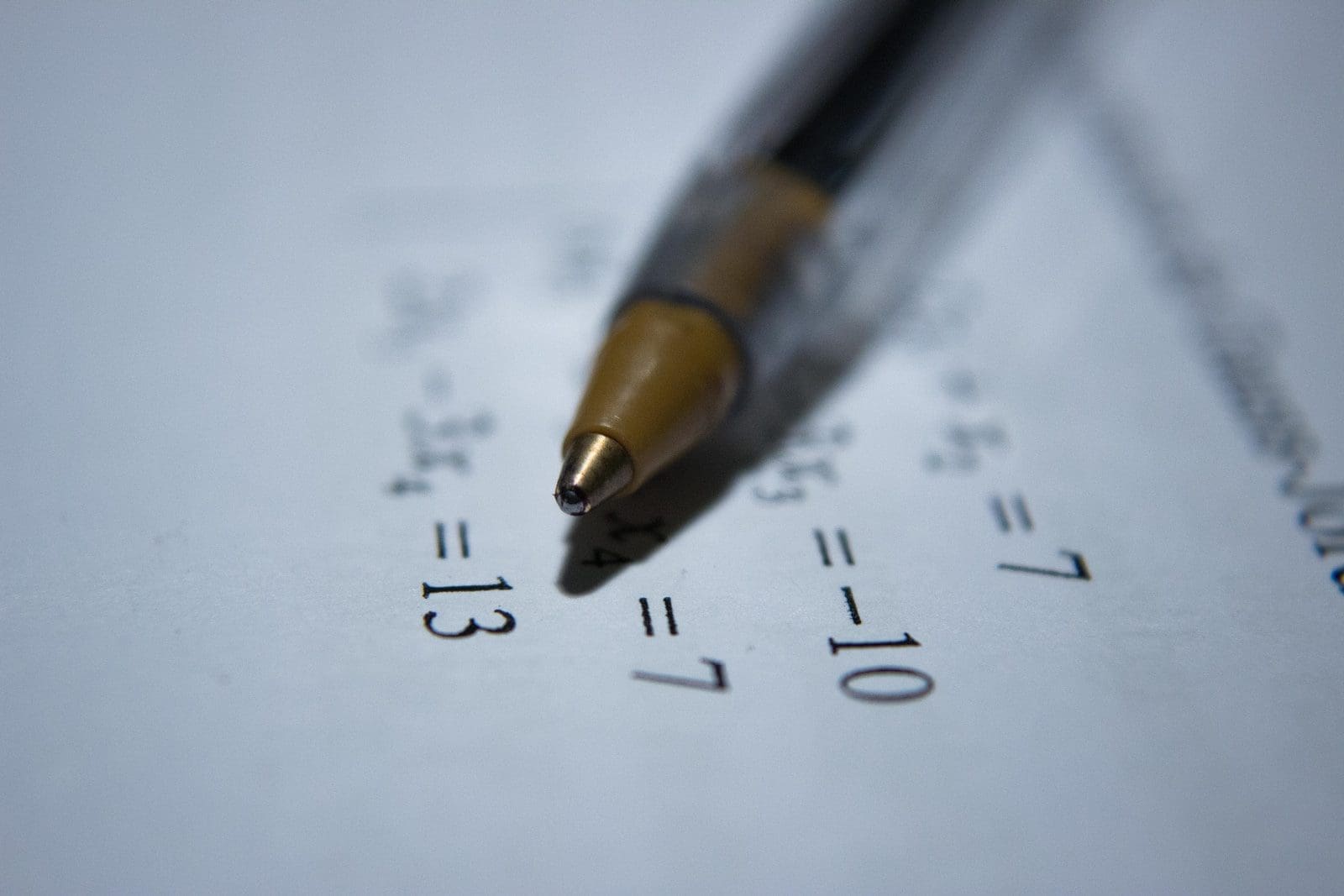 math olympiad black retractable pen on white printer paper