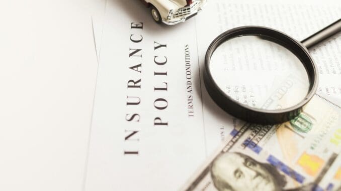 a magnifying glass sitting on top of a piece of paper Insurance calculator